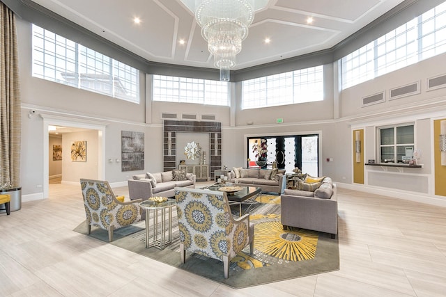 living area with visible vents, baseboards, a notable chandelier, and coffered ceiling