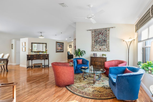 living area featuring visible vents, light wood-style flooring, baseboards, lofted ceiling, and ceiling fan