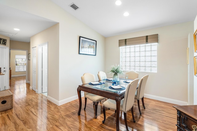 dining room featuring baseboards, visible vents, recessed lighting, vaulted ceiling, and light wood-style floors
