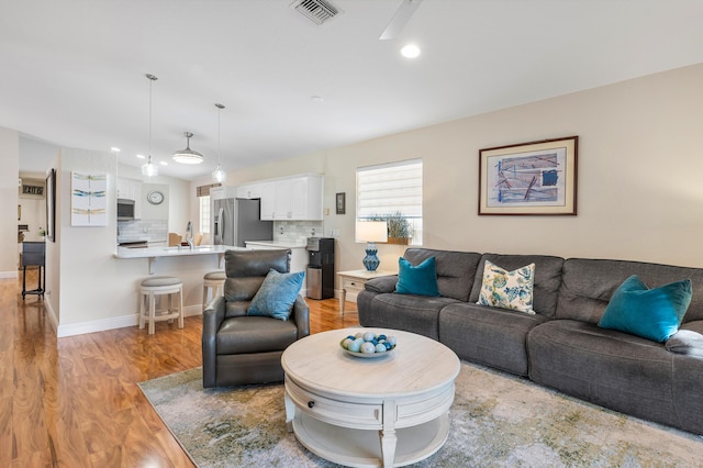 living room featuring sink and light hardwood / wood-style flooring