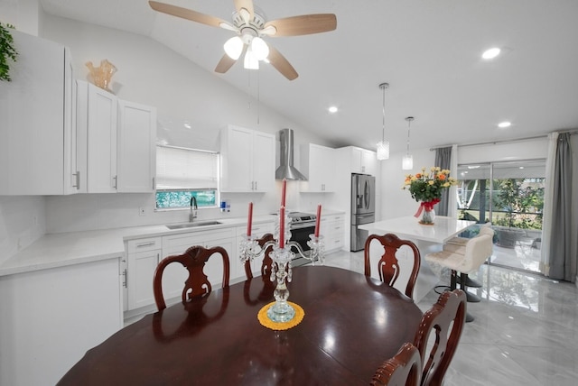 dining area featuring sink, ceiling fan, a wealth of natural light, and vaulted ceiling