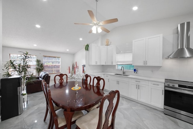 dining area with ceiling fan, vaulted ceiling, and sink