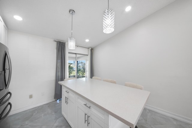 kitchen with white cabinetry, decorative light fixtures, and a kitchen island