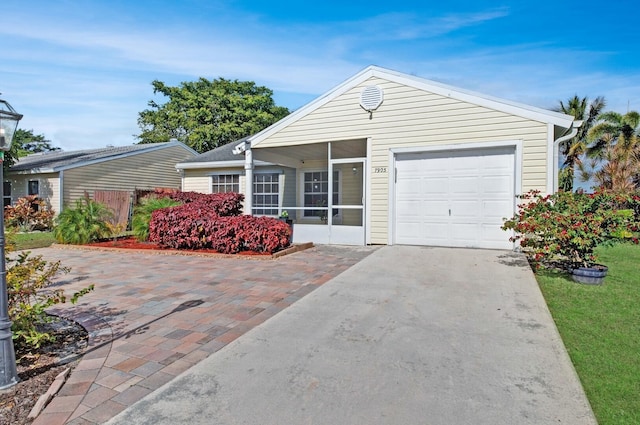 single story home featuring a garage and a sunroom