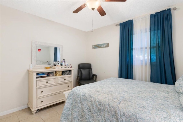 tiled bedroom with ceiling fan and a textured ceiling