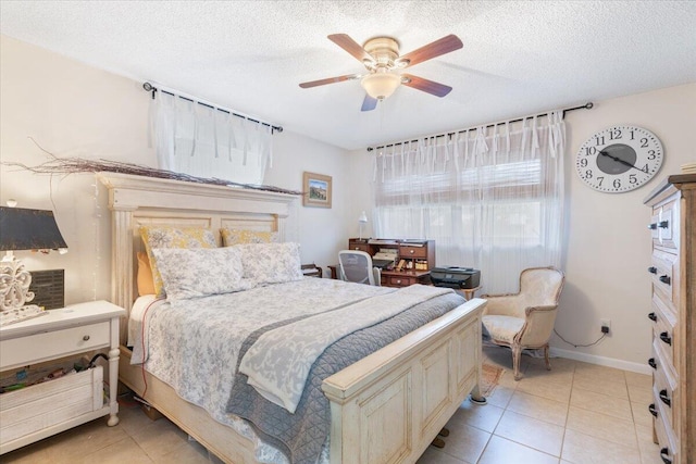 bedroom featuring ceiling fan, light tile patterned floors, and a textured ceiling