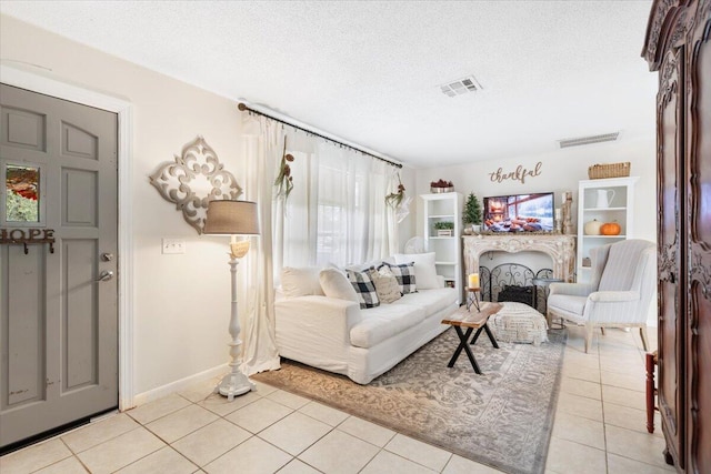 tiled living room featuring a textured ceiling