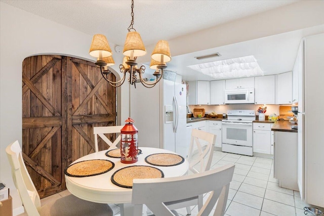 dining area with a notable chandelier, light tile patterned flooring, and a textured ceiling