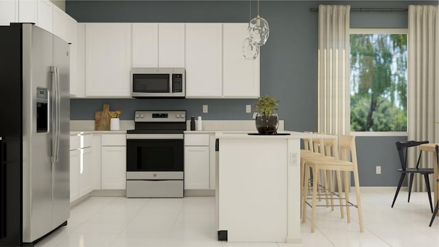 kitchen featuring appliances with stainless steel finishes, light tile patterned floors, white cabinetry, and pendant lighting