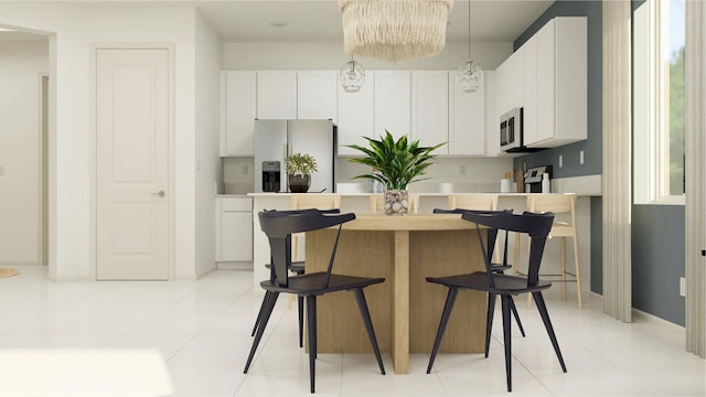 kitchen featuring stainless steel appliances, light tile patterned floors, white cabinetry, a notable chandelier, and a kitchen island