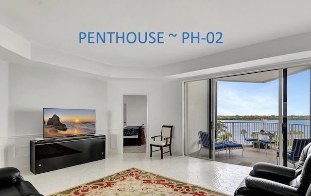 living room featuring a tray ceiling and a water view