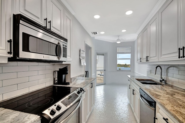 kitchen featuring white cabinetry, stainless steel appliances, light stone countertops, and sink