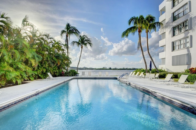 view of pool featuring a patio area and a water view