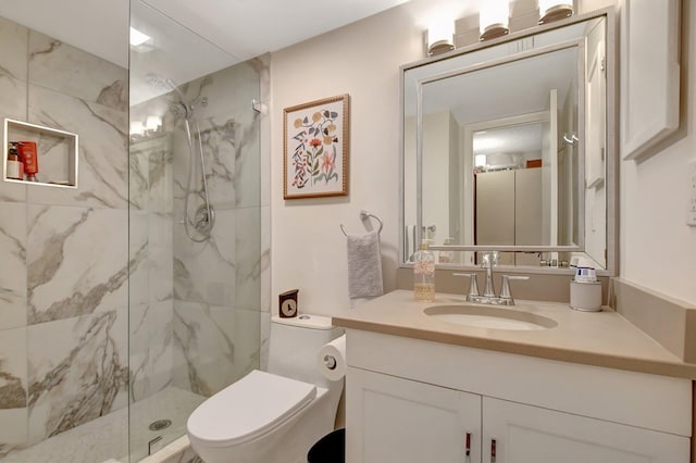 bathroom with a shower with door, vanity, and toilet