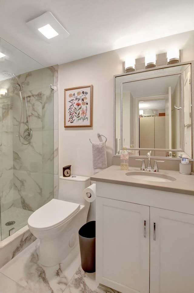 bathroom featuring tiled shower, vanity, and toilet