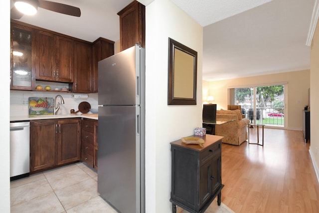 kitchen featuring backsplash, sink, ceiling fan, dark brown cabinets, and stainless steel appliances