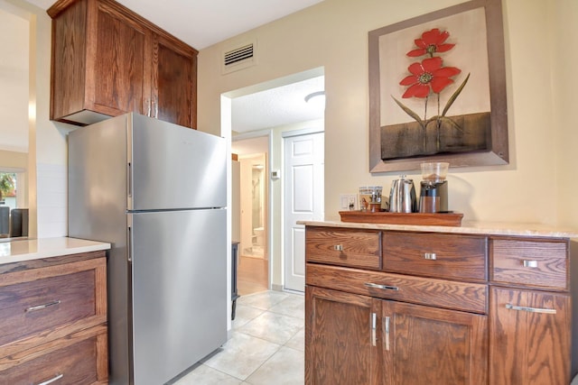 kitchen with stainless steel fridge and light tile patterned flooring