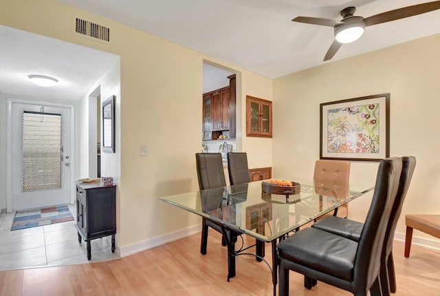 dining space with ceiling fan and light hardwood / wood-style floors