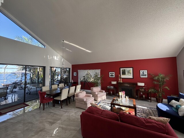 entryway with a textured ceiling, wood-type flooring, high vaulted ceiling, and a healthy amount of sunlight