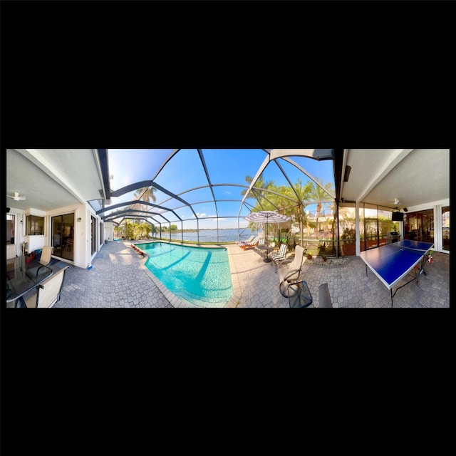 view of swimming pool featuring a lanai and a patio