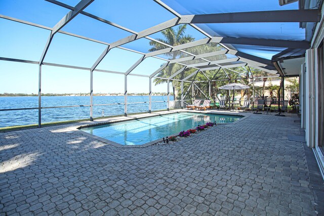 view of pool with a water view, a lanai, and a patio area