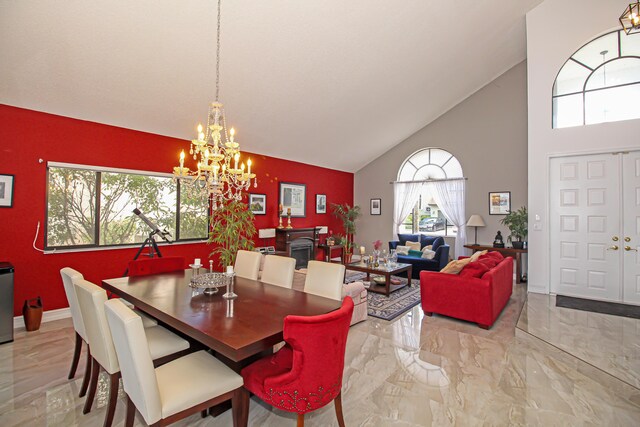 dining space with high vaulted ceiling, an inviting chandelier, and a textured ceiling