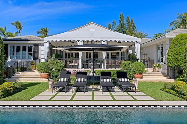 back of house with a patio area, a fenced in pool, and a yard