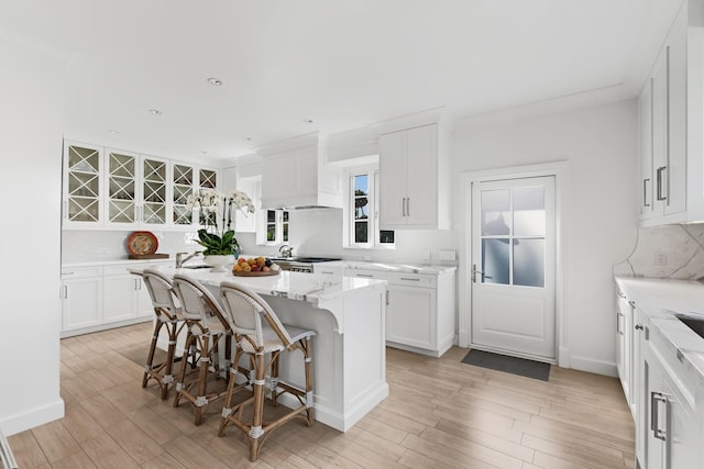 kitchen featuring white cabinets, a kitchen island, and a kitchen bar