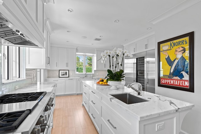 kitchen featuring a center island, high end appliances, premium range hood, sink, and white cabinetry