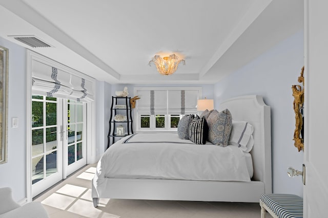 tiled bedroom with a tray ceiling, french doors, access to outside, and multiple windows