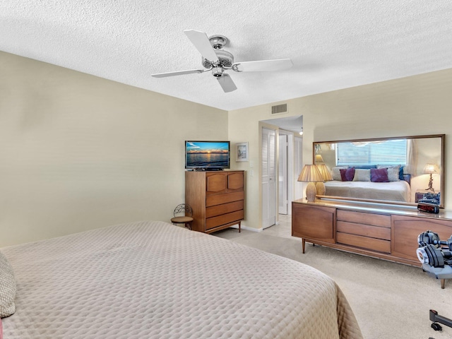 carpeted bedroom featuring ceiling fan and a textured ceiling