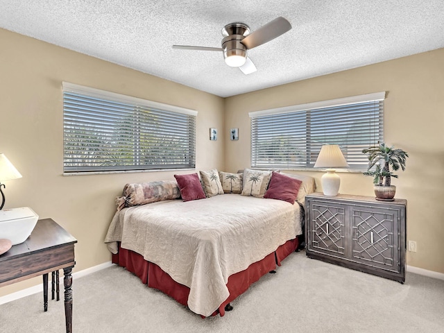 carpeted bedroom featuring multiple windows, ceiling fan, and a textured ceiling