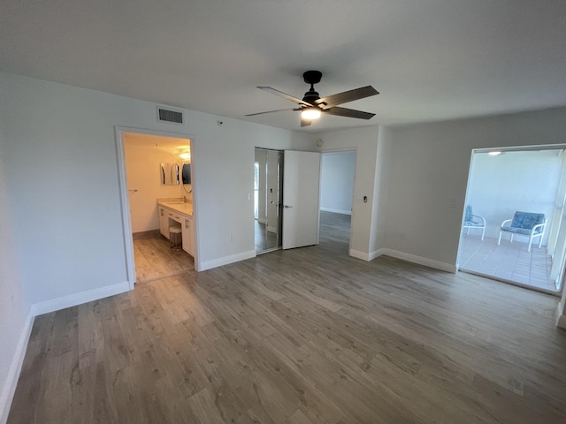 interior space with ceiling fan, ensuite bathroom, and light hardwood / wood-style floors