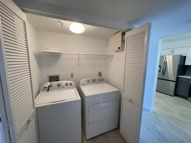 laundry room featuring washing machine and clothes dryer and light wood-type flooring