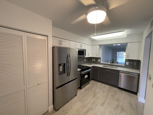 kitchen with white cabinets, decorative backsplash, stainless steel appliances, and sink