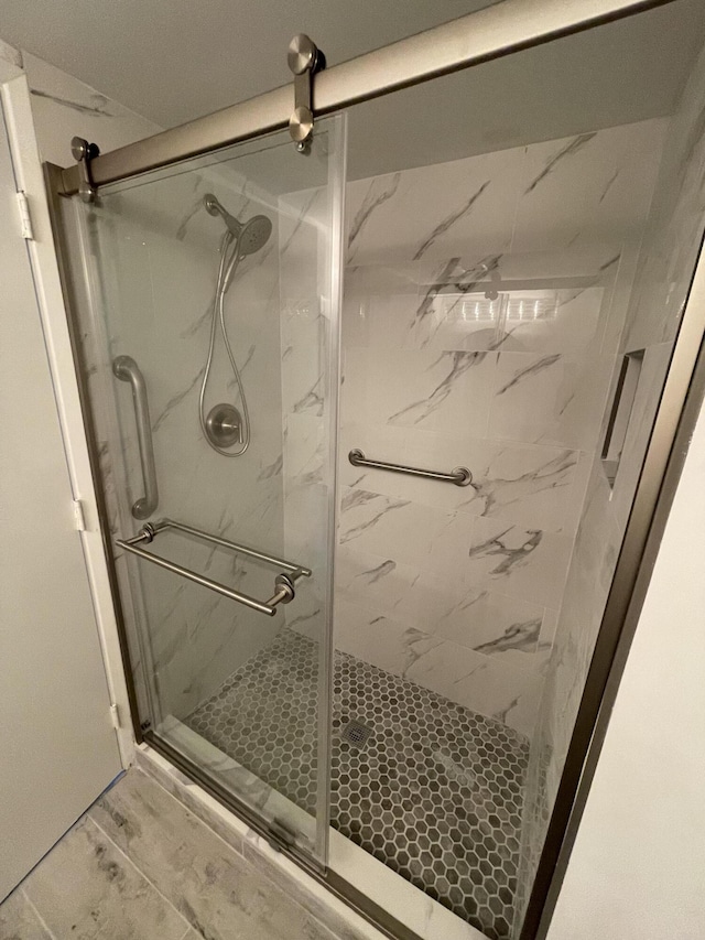 bathroom with a shower with door