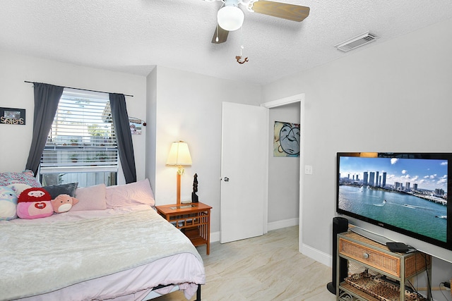 bedroom with a textured ceiling and ceiling fan