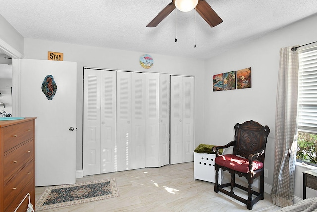 living area featuring ceiling fan, a wealth of natural light, sink, and a textured ceiling