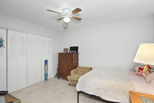 bedroom with a textured ceiling, ceiling fan, and a closet