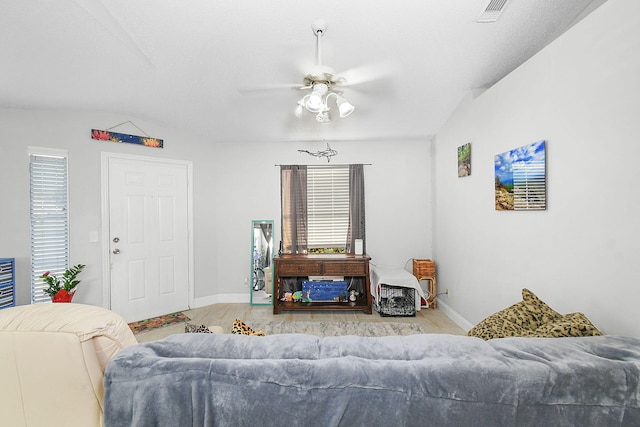 living room with light wood-type flooring, ceiling fan, lofted ceiling, and a textured ceiling