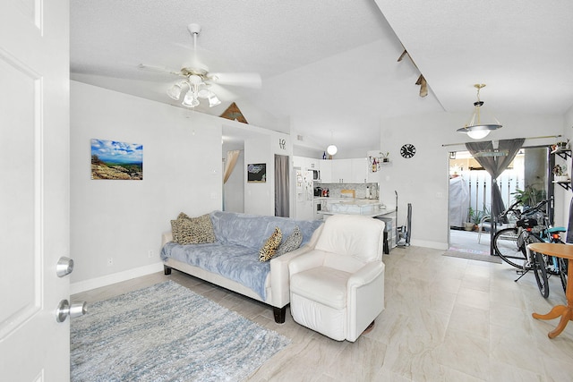 living room featuring ceiling fan, vaulted ceiling, and a textured ceiling