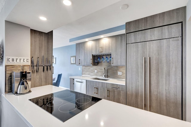 kitchen featuring paneled refrigerator, black electric stovetop, backsplash, dishwasher, and sink