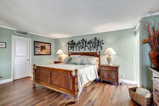 bedroom with a textured ceiling, crown molding, and hardwood / wood-style flooring