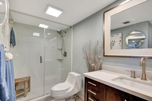 bathroom featuring toilet, a shower with shower door, and vanity