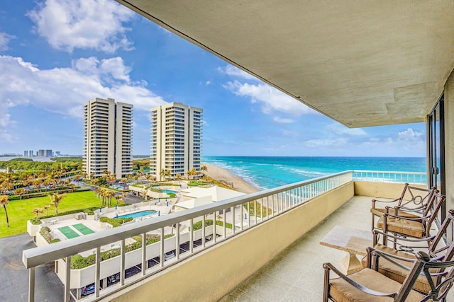 balcony featuring a water view and a beach view