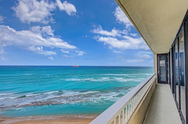 balcony with a water view and a beach view