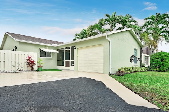 single story home with a front yard and a garage