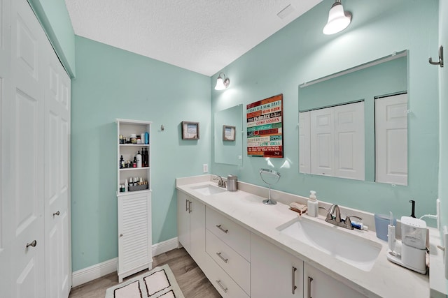 bathroom featuring hardwood / wood-style flooring, a textured ceiling, and vanity