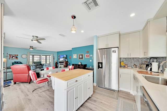 kitchen featuring sink, pendant lighting, appliances with stainless steel finishes, and light wood-type flooring