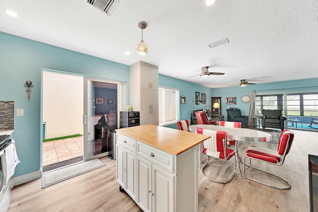 kitchen featuring ceiling fan, plenty of natural light, a kitchen island, and pendant lighting